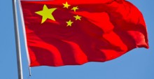 33784466 - chinese flag with flag pole waving in the wind over blue sky background.