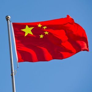 33784466 - chinese flag with flag pole waving in the wind over blue sky background.
